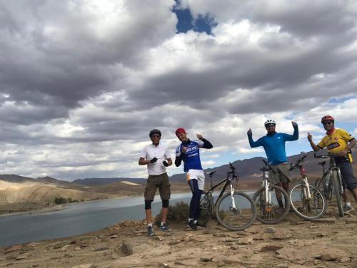 a group of men standing on a hill with their bikes at Auberge restaurant Afoud in Agoudal