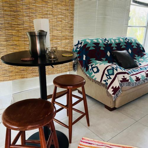 a table and two stools next to a bed at El Hoy in Tampa