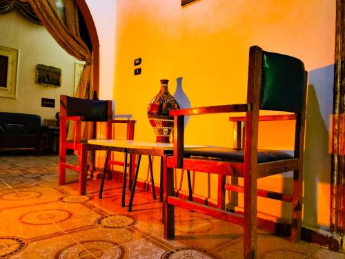 a dining room with a table and chairs and a vase at Safari Abu Simbel in Abu Simbel
