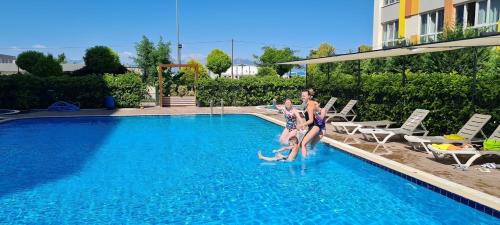 Dos mujeres están saltando a una piscina en Lego Residence Pool & Security & City Center & 5 star en Antalya