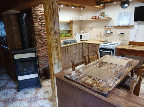 cocina con estufa de leña y mesa en Chata Evka, en Ružomberok