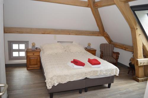 a bedroom with a bed with two red towels on it at Herberg d'n Driesprong in Zeeland