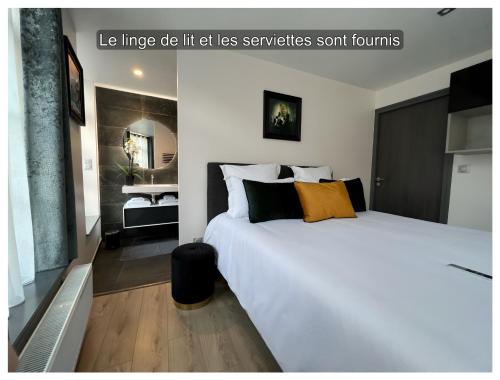 1 dormitorio con 1 cama blanca grande con almohadas de color naranja y negro en Maison Hyper Centre d’Arras, en Arras