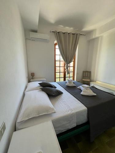 a large bed in a room with a window at Maison Umberto I a Villasimius centro in Villasimius
