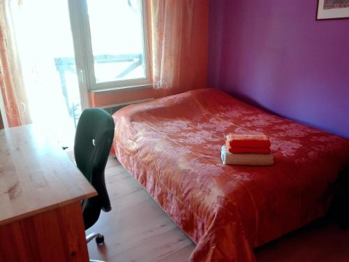 a bedroom with a red bed with a desk and a window at Brīvdienu māja"Jauneglites" in Skulte