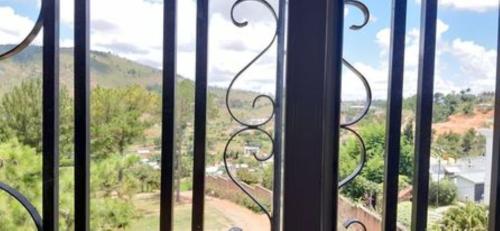 une fenêtre ouverte avec vue sur la montagne dans l'établissement VILLAPPART troisième étage, à Antananarivo