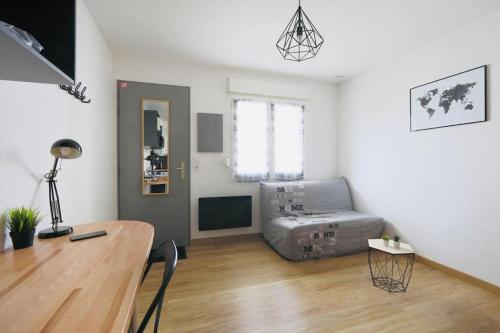Una habitación con escritorio y una cama en una habitación en Studio proche Tours avec wifi en Chambray-lès-Tours