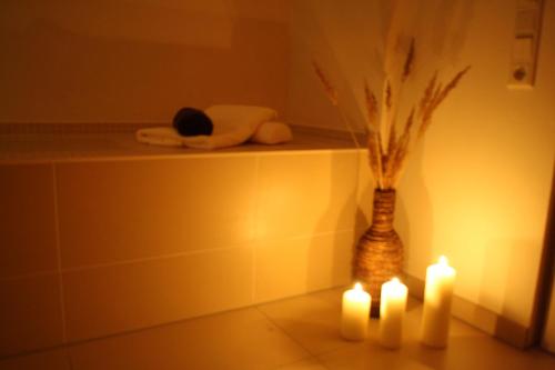 a bathroom with two candles and a vase of flowers at Pension Hotel Sartor in Kurort Altenberg