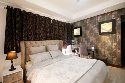 a bedroom with a large white bed and curtains at 3 Bedroom in Tuscany Private Estate BGC in Manila