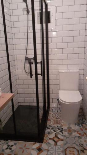 a bathroom with a shower and a toilet at Casa con piscina climatizada y barbacoa in Freigido