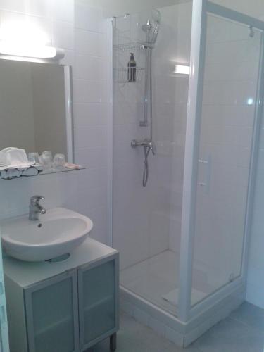 une salle de bain blanche avec une douche et un lavabo dans l'établissement Les appART Le Havre Centre & Mer, au Havre