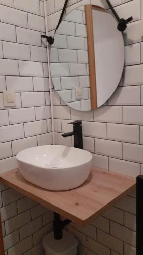a bathroom with a white sink and a mirror at Casa con piscina climatizada y barbacoa in Freigido