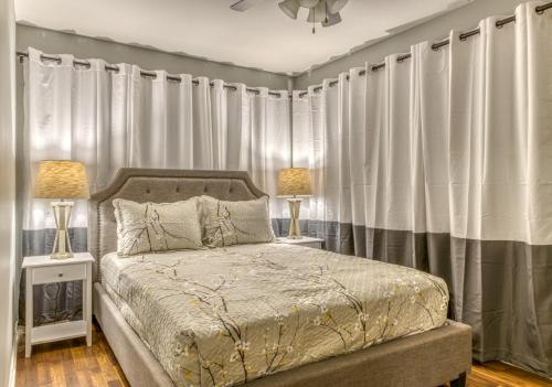 - une chambre avec un lit avec des rideaux et 2 lampes dans l'établissement Huge Yard Familyfriendly Smarthome Walk To Beach Dunes Hiking Trails, à Miller
