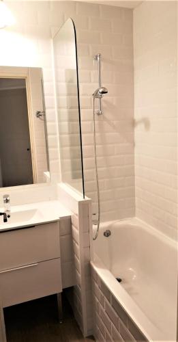 une salle de bain blanche avec une baignoire et un lavabo dans l'établissement Flo & Rose Azur - Duplex vue mer terrasses piscine jardins parking, à Cannes