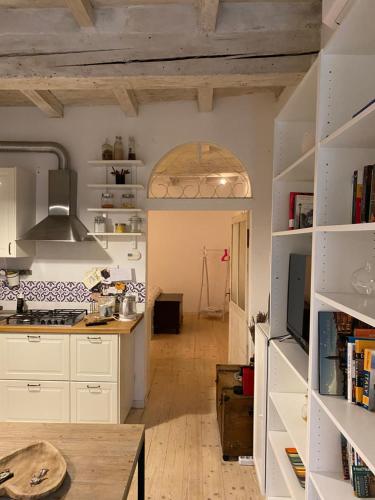 cocina con armarios blancos y mesa de madera en Casina Centotrecento-Romantic & Quite Apartment-, en Bolonia