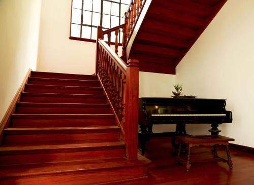 a staircase with a piano in a room at Hotel Boutique El Libertador in Zipaquirá