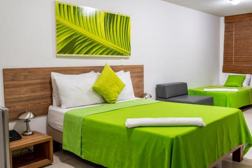 Un dormitorio con una cama verde y una silla en Hotel Condina Pereira, en Pereira