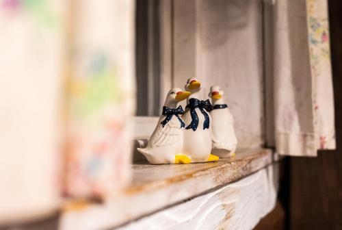 two rubber ducks sitting on a window sill at Domki Osada Werdołyna in Polańczyk