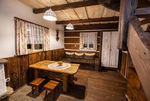 jadalnia z drewnianym stołem i krzesłami w obiekcie Domki Osada Werdołyna w Polańczyku