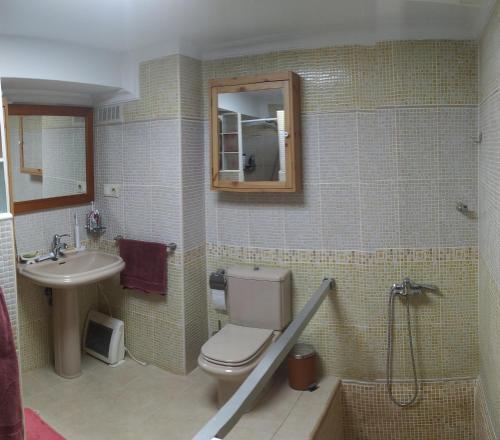a bathroom with a toilet and a sink and a mirror at Luz de Carboneras in Carboneras de Guadazaón