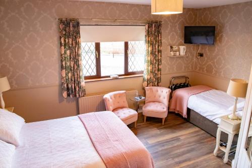 a bedroom with two beds and a window at The Ring Farmhouse in Birr