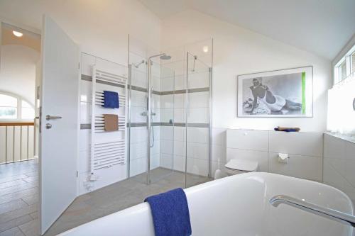 Kramerhof的住宿－Sundbrise，白色的浴室设有浴缸和玻璃淋浴间。