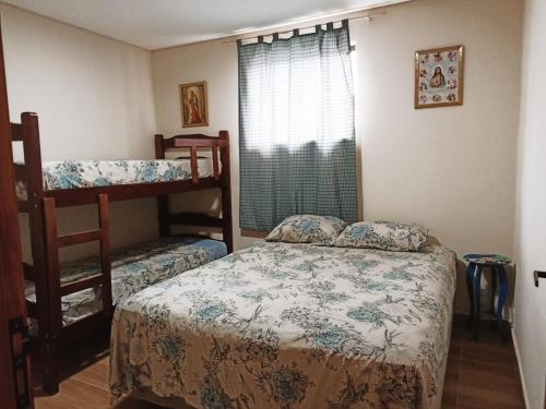 a bedroom with two bunk beds and a window at Casa a 5 minutos a pé da Basílica e da feira em Aparecida in Aparecida