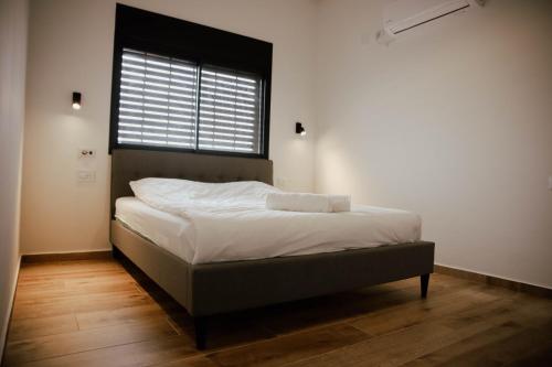 łóżko w pokoju z dużym oknem w obiekcie Cozy Beautiful Guest House w mieście HaZore‘im
