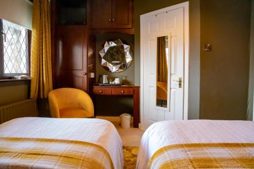 a bedroom with two beds and a mirror on the wall at The Ring Farmhouse in Birr