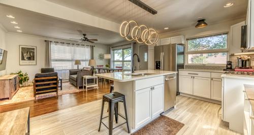 a kitchen and living room with a couch in the background at Modern Beach Bungalow, Firepit, Foosball, Hot tub, IN Dunes Natl Park in Miller