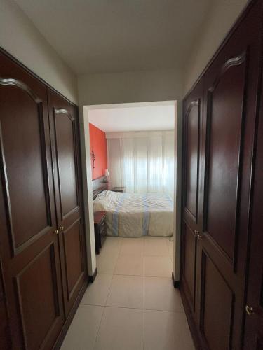 Un pasillo con un dormitorio con una cama. en Acogedor apartamento en norte - 2 habitaciones, en Bogotá