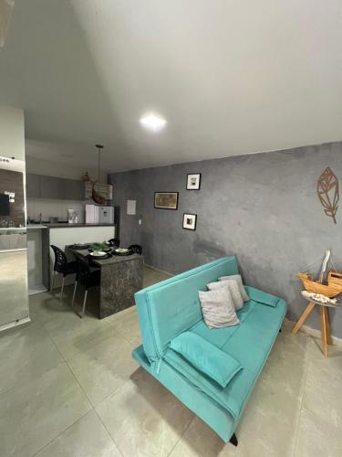 a living room with a blue couch and a kitchen at casamarfrances in Praia do Frances