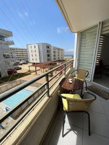 a balcony with a table and chairs and a view of a building at Descanso y Aire Fresco en Los Molles in Los Molles