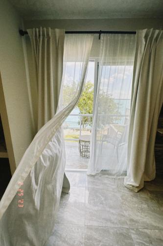 a room with a window with curtains on it at Hotel Awazul Bacalar in Bacalar