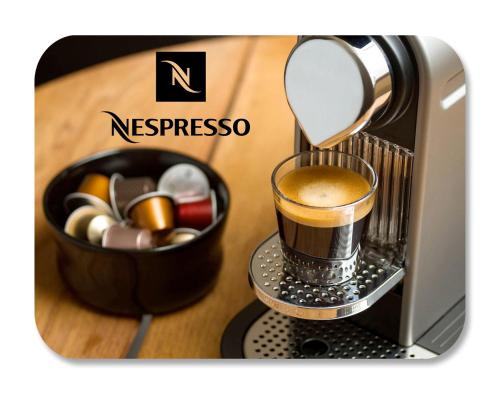 a coffee maker with a cup of coffee and a bowl of candy at Chueca Gran Via Apartaments TPH in Madrid