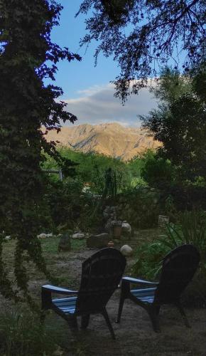 dos sillas sentadas en un patio con montañas al fondo en Casa Luz y Armonía en Villa Las Rosas