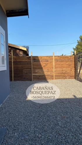 a sign on the ground in front of a fence at Cabaña bosquepaz in Algarrobo