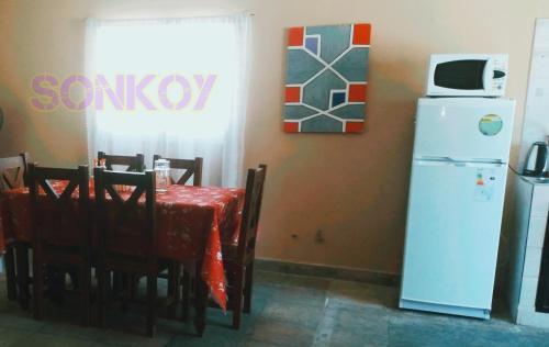 a kitchen with a table and a white refrigerator at SONKOY APART in San Salvador de Jujuy