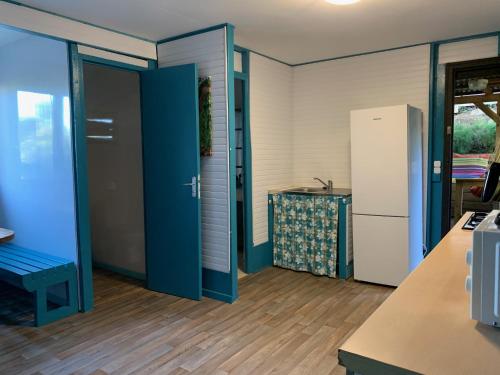 a kitchen with a blue door and a refrigerator at an eol caraibes in Trois-Rivières