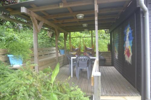 a wooden porch with a table and chairs on it at an eol caraibes in Trois-Rivières