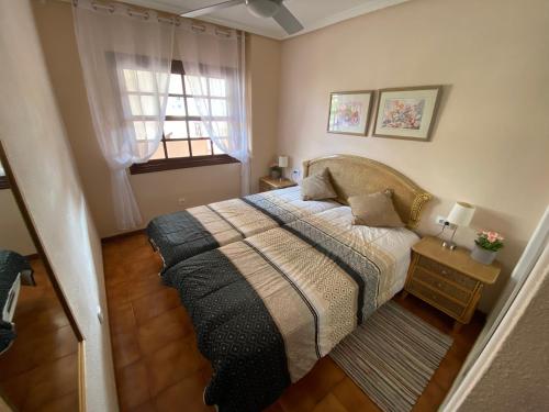 um quarto com uma cama e uma janela em Vive Rie Ama Tenerife - 2 bedroom apartment em San Miguel de Abona