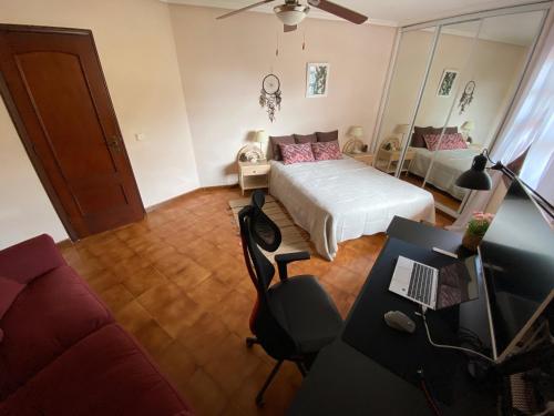 um quarto com uma cama e uma secretária com um computador portátil em Vive Rie Ama Tenerife - 2 bedroom apartment em San Miguel de Abona