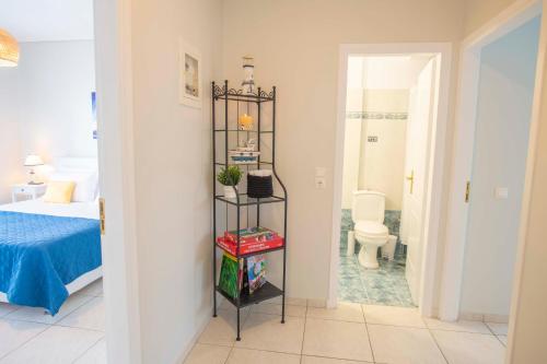 a room with a bedroom with a toilet and a shelf at Kima: Relaxing beach home next to sparkling waters in Nea Makri