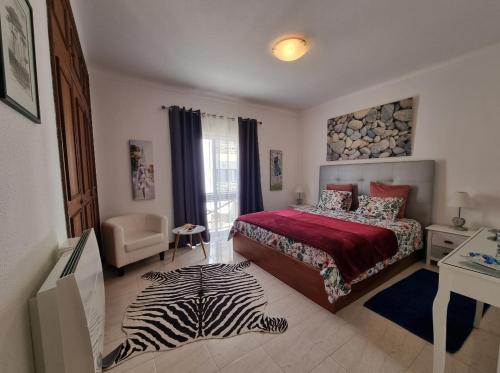 1 dormitorio con cama y alfombra de cebra en Apartmento Praia da Dona Ana, en Lagos