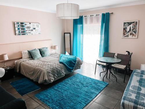 a bedroom with a bed and a table and blue rugs at Merry's House in Lagos