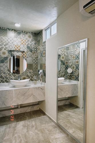 a bathroom with two sinks and a mirror at Hotel Awazul Bacalar in Bacalar