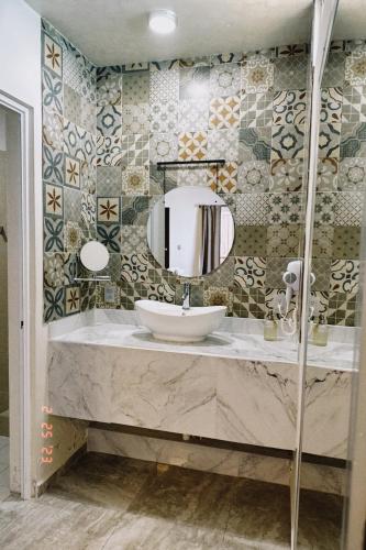 a bathroom with a sink and a mirror at Hotel Awazul Bacalar in Bacalar