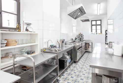 una gran cocina blanca con electrodomésticos de acero inoxidable en Dwór Sędzisław 
