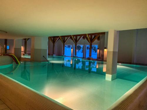 a swimming pool in a hotel with the lights on at Heimelige Ferienwohnung mit Sicht in die Bergwelt in Bivio