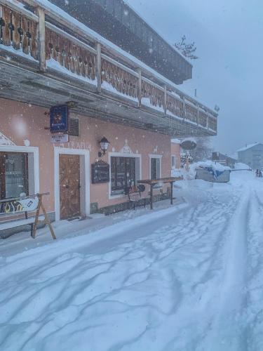 a building with snow on the ground in front of it at Heimelige Ferienwohnung mit Sicht in die Bergwelt in Bivio